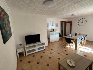 a living room with a television and a dining room at Albalat Centro in Albalat de la Ribera
