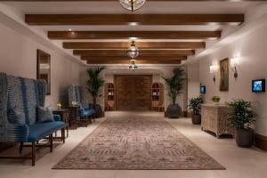 a lobby with a door and chairs and a rug at La Bahia Hotel & Spa in Santa Cruz