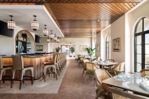 a restaurant with tables and chairs and a bar at La Bahia Hotel & Spa in Santa Cruz