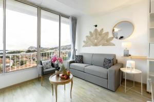 a living room with a couch and a table at Tableau de La Ciotat - Host Provence in La Ciotat