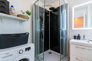 a glass shower in a bathroom with a washing machine at Cosy Home proche RER in Noisy-le-Grand +18 photos