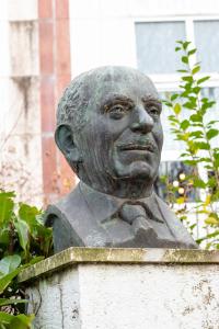 a statue of a man sitting on top of a wall at Cosy Home proche RER in Noisy-le-Grand