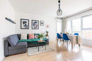 a living room and dining room with a couch and a table at Cosy Home proche RER in Noisy-le-Grand