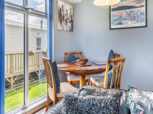 a dining room with a table and chairs and a window at Tranquillity in Dinas