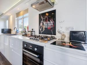 a kitchen with a stove top oven next to a counter at Tranquillity in Dinas