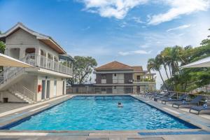 a swimming pool with chairs and a house at Afro Park Hotel in Kampala
