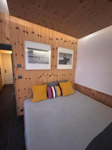 a bedroom with a bed with a wooden wall at Útulný apartmán Vitkovice in Vítkovice