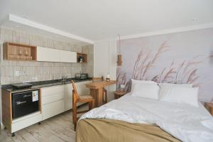 a bedroom with a large bed and a kitchen at Boho Suites in Tafí del Valle