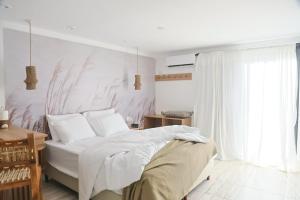 a bedroom with a white bed and a window at Boho Suites in Tafí del Valle
