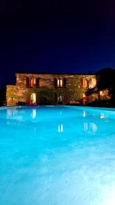 a large pool of blue water in front of a building at Chambres de charme in Corte +1 photo
