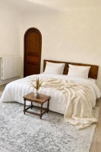 a bedroom with a large white bed with a table at Chambres de charme in Corte