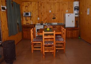 a kitchen with a table and chairs and a stove at Cabañas Soledad in Villa Giardino +7 photos