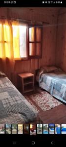 a room with two beds and a window at Cabañas Soledad in Villa Giardino