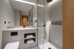 a bathroom with a shower and a sink and a mirror at Residence Inn Lisbon by Marriott Hotel in Lisbon +38 photos