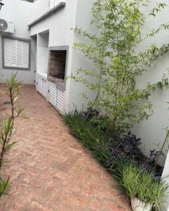 a brick driveway next to a white building at Hospedaje Adha Chivilcoy III in Chivilcoy
