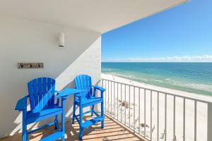 two blue chairs on a balcony overlooking the beach at Perdido Skye 64 in Pensacola
