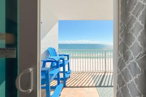 a pair of blue chairs on a balcony with the ocean at Perdido Skye 64 in Pensacola