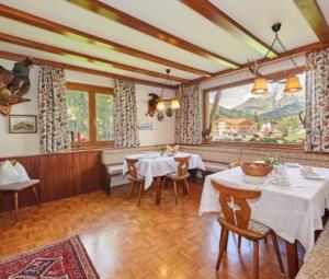 a restaurant with tables and chairs and a large window at Haus Traudl in Filzmoos