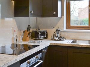 a kitchen with a sink and a toaster on the counter at Carp Cottage - Ukc1907 in Doddington