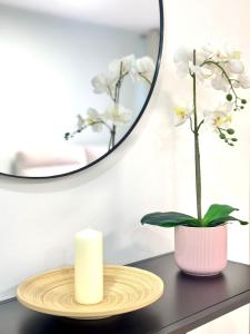 a candle and a plant on a table with a mirror at NextGen Dimora Luna I Private Garden & Pool Fuerteventura in Costa de Antigua