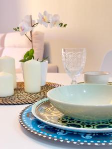 a table with a bowl and a plate and glasses at NextGen Dimora Luna I Private Garden & Pool Fuerteventura in Costa de Antigua