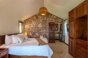 a bedroom with a large bed and a stone wall at Ana y Jose Tulum Hotel & Beach Club in Tulum +164 photos