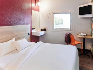 a bedroom with a large white bed and a window at hotelF1 Rouen Zénith Parc Expo in Saint-Étienne-du-Rouvray