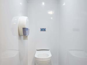 a white bathroom with a toilet and a phone at hotelF1 Rouen Zénith Parc Expo in Saint-Étienne-du-Rouvray