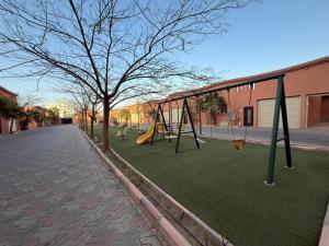 an empty playground with swings in a street at شاليهات وشقق ليالي رهيف in Abha
