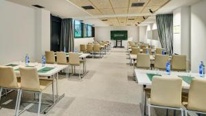 a conference room with tables and chairs and a projection screen at Sercotel Barcelona El Prat in El Prat de Llobregat +41 photos
