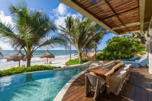 an outdoor dining area with a table and chairs and the beach at Ana y Jose Tulum Hotel & Beach Club in Tulum