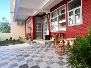 a patio with a table and chairs in front of a house at Ayu Aanandam - Live I Heal I Rest in Rishīkesh