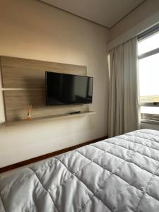a bedroom with a bed and a flat screen tv at The One DownTown Costanera in Asunción