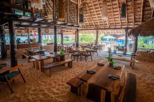 a restaurant with wooden tables and chairs in a room at Ana y Jose Tulum Hotel & Beach Club in Tulum