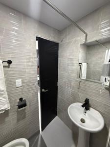 a bathroom with a white sink and a toilet at Moon Apartamentos C1 in San Cristóbal
