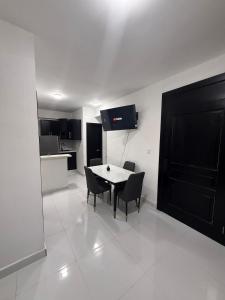 a dining room with a table and chairs and a kitchen at Moon Apartamentos C1 in San Cristóbal