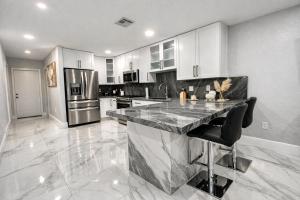 a large kitchen with a marble counter top at Villa Miami Lakes in Hialeah