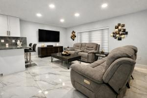 a living room with two couches and a television at Villa Miami Lakes in Hialeah