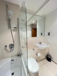 a bathroom with a shower and a toilet and a sink at Comfy 2bed flat next to Motorpoint Arena in Nottingham +19 photos