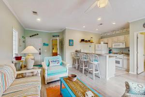 a living room with a couch and a kitchen at SB50 Saltwater Sanctuary in Sunset Beach