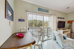 a living room with a table and a balcony at SB50 Saltwater Sanctuary in Sunset Beach