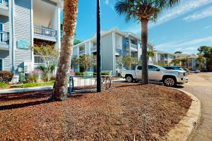 a white truck parked in front of a building with palm trees at SB50 Saltwater Sanctuary in Sunset Beach