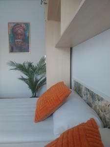 a bed with two orange pillows on top of it at Apartamento El Horrín ( Colunga ) in Colunga