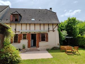 a house with a table and chairs in the yard at Les colombages bis in Pazayac