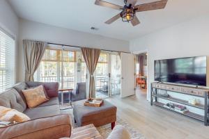 a living room with a couch and a flat screen tv at SB72 Sea Trail Golf-Beach Condo in Sunset Beach