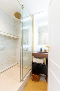 a bathroom with a glass shower and a sink at Prestige Étretat in Étretat +31 photos