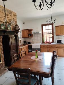 a kitchen with a wooden table and a dining room at Les colombages bis in Pazayac