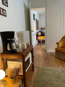 a living room with a table with a microwave at Suite - Chambre Cherry Plum in Coulommiers +5 photos