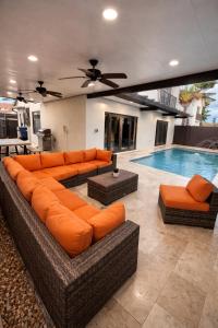 a living room with orange furniture and a swimming pool at Villa Miami Lakes 2 in Hialeah
