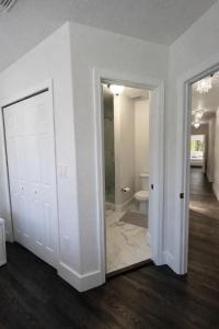 a white room with a door and a bathroom at Villa Miami Lakes 2 in Hialeah +14 photos